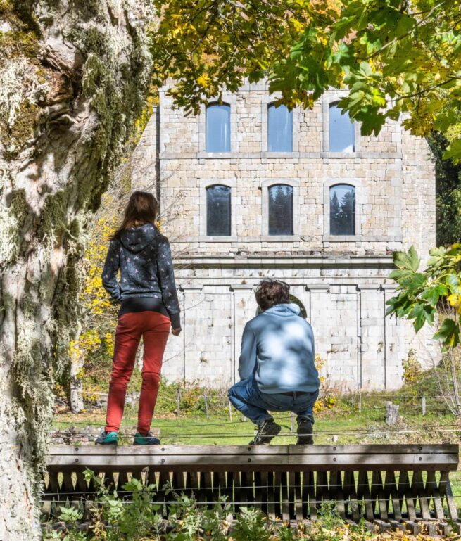amis sur plateforme en bois devant un ancien bâtiment en pierre