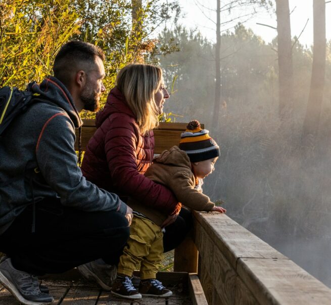 famille accroupie sur ponton face à un étang