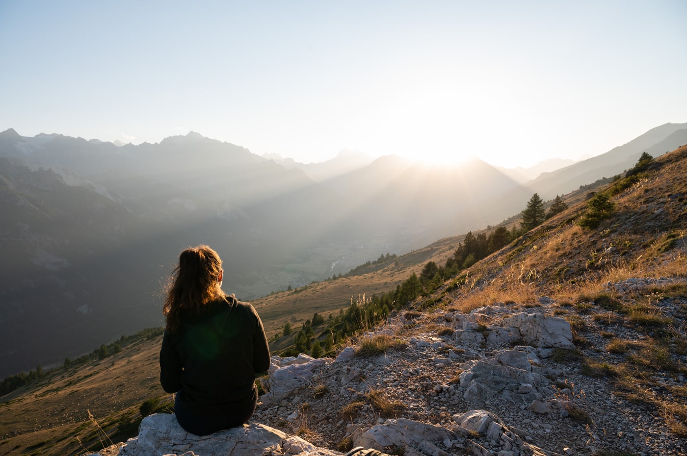 randonneur face au coucher du soleil en montagne