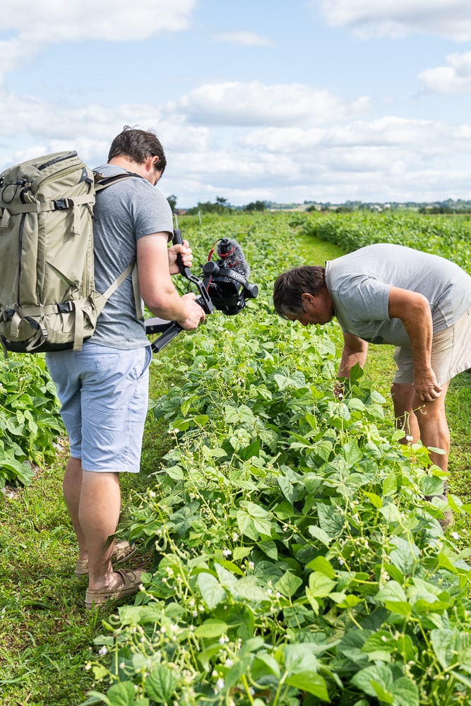 vidéaste en action avec un maraicher dans un champ