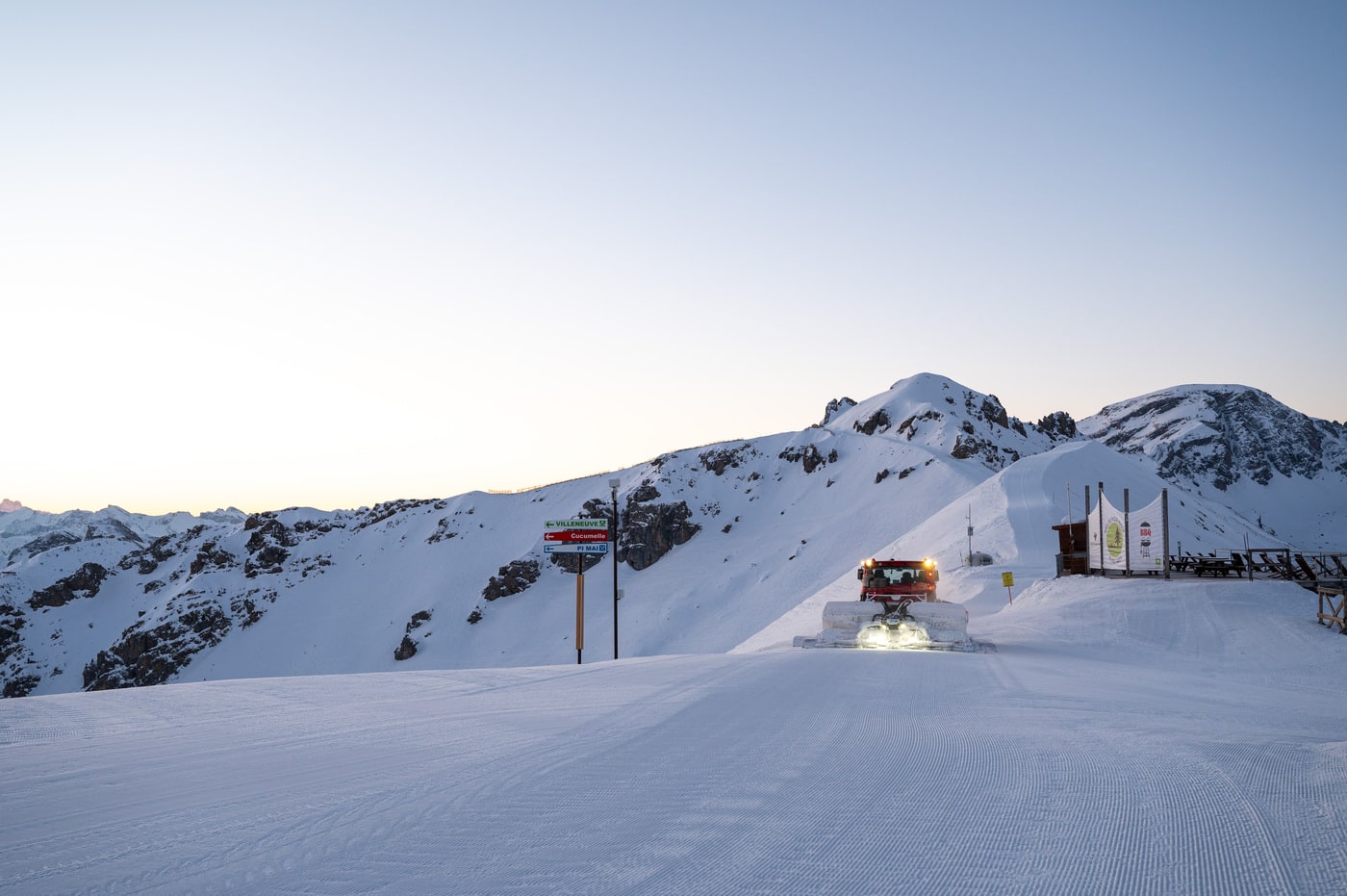 dameuse au sommet des pistes au lever du soleil