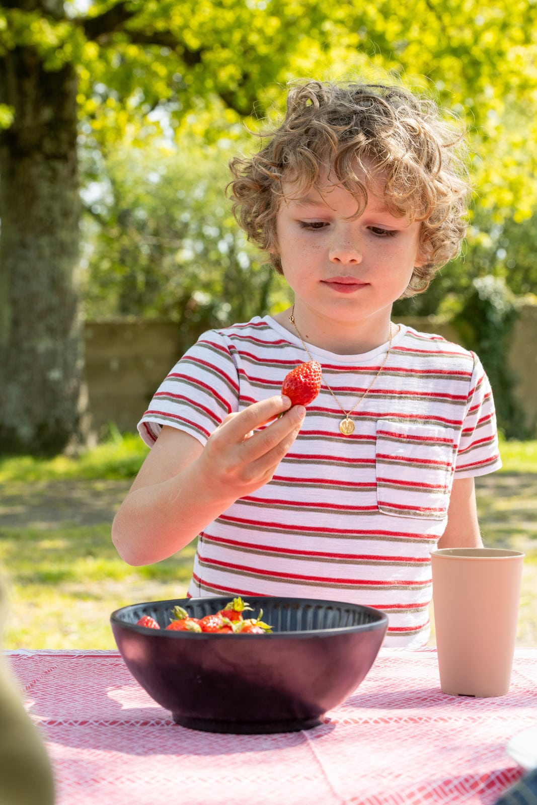 enfant qui mange une fraise