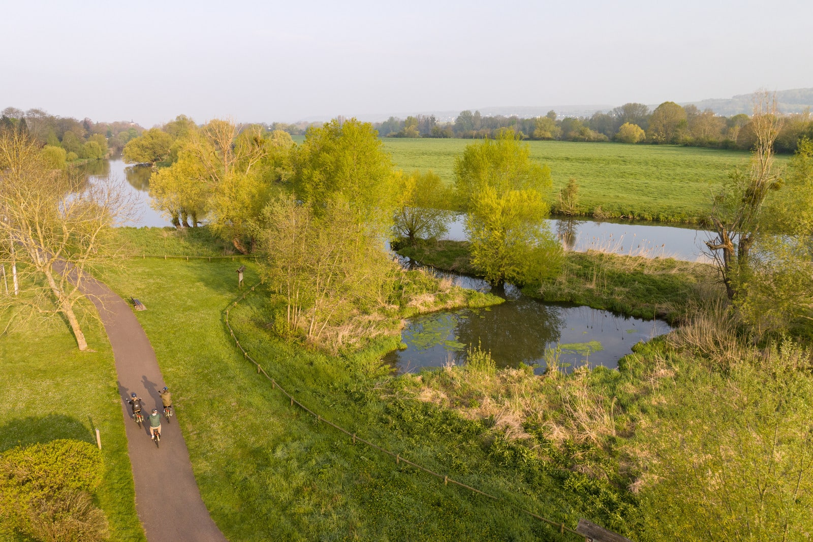 vélos en bord de fleuve avec péniche en drone