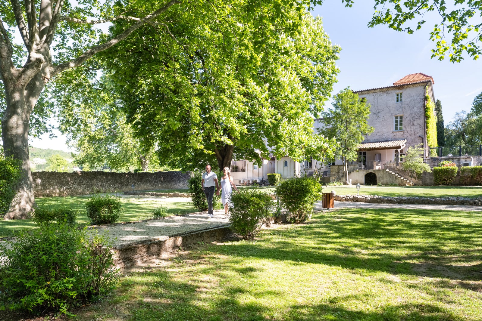 couple se promène dans le jardin de l'hôtel