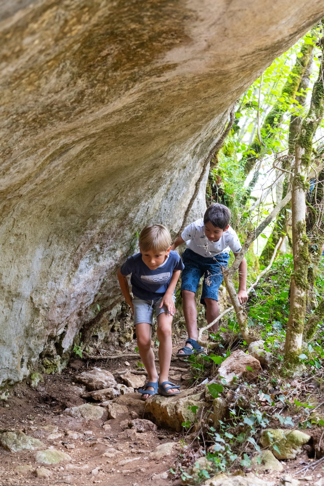 enfants marchent sous une roche
