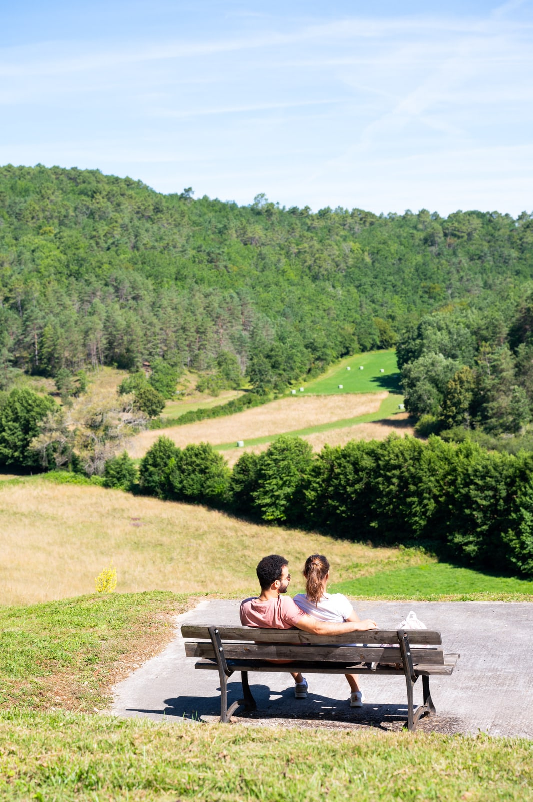 couple assis sur un banc face au paysage
