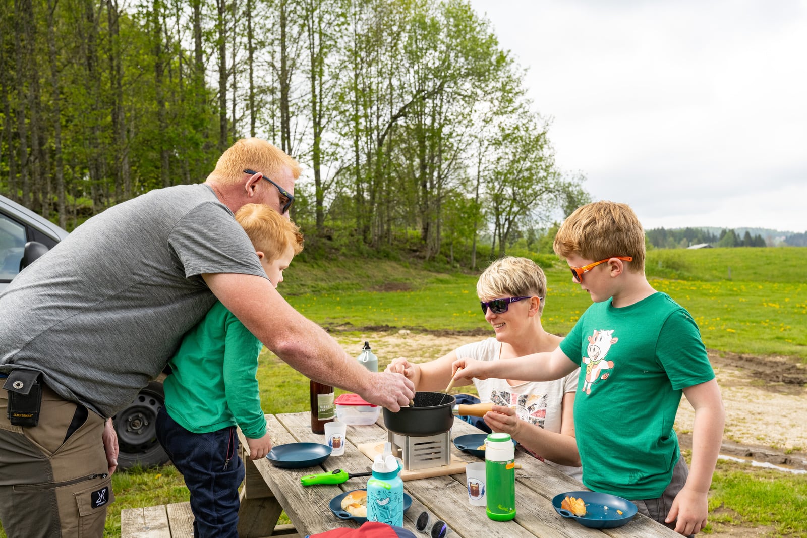 famille mange une fondue sur table de pique nique