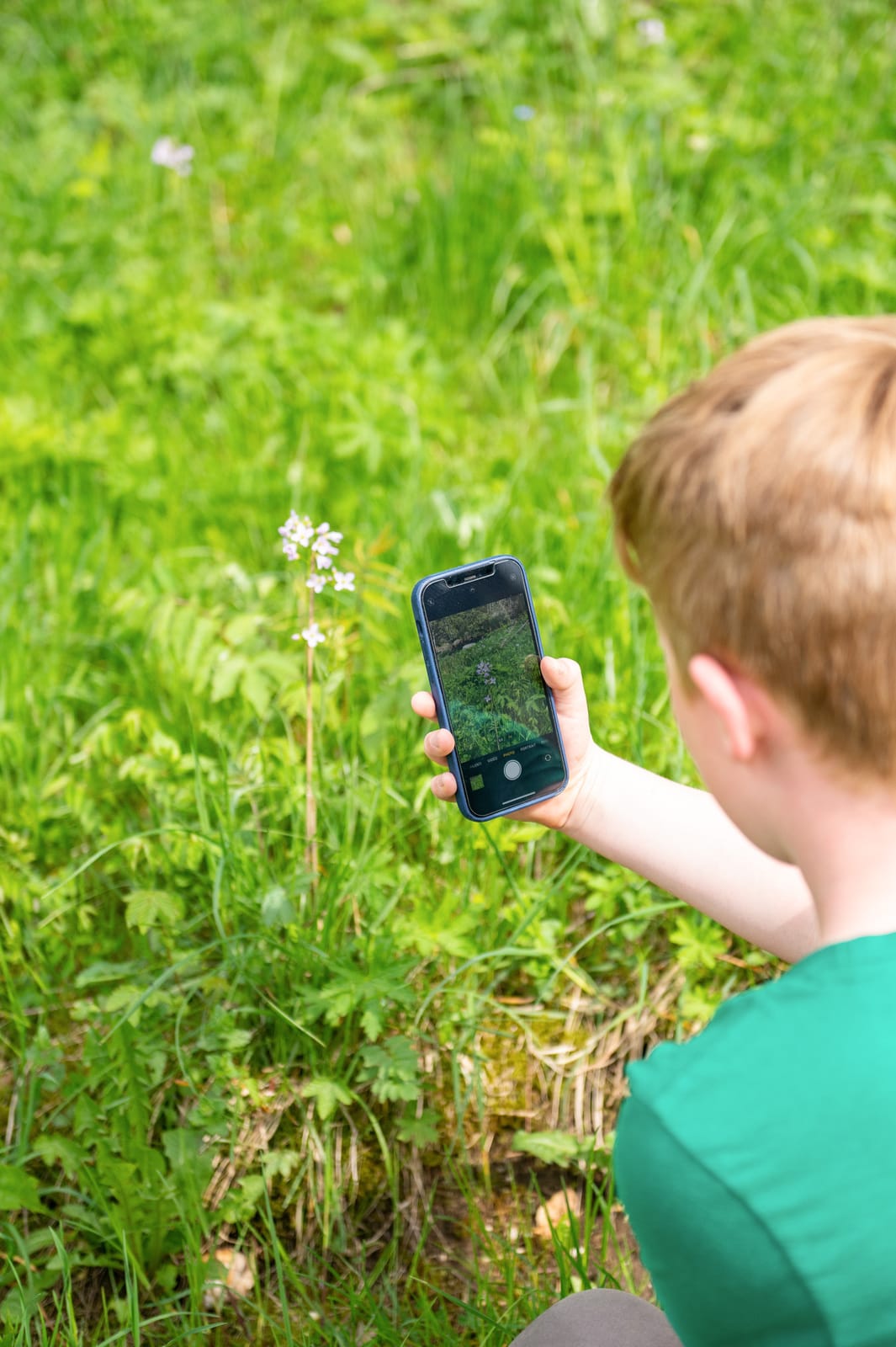 enfant prend en photo une fleur