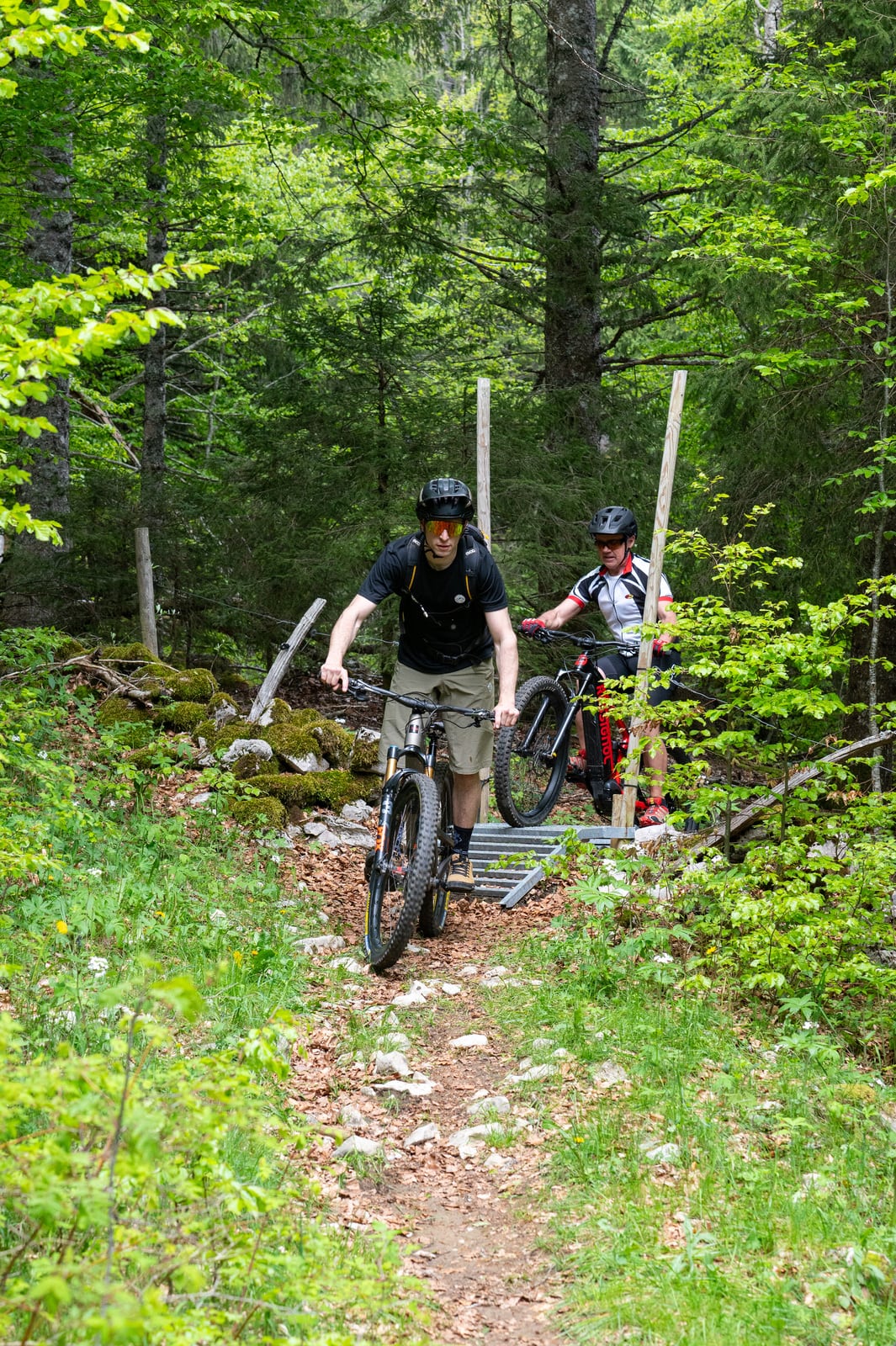 vttistes traversent un passage de barrière