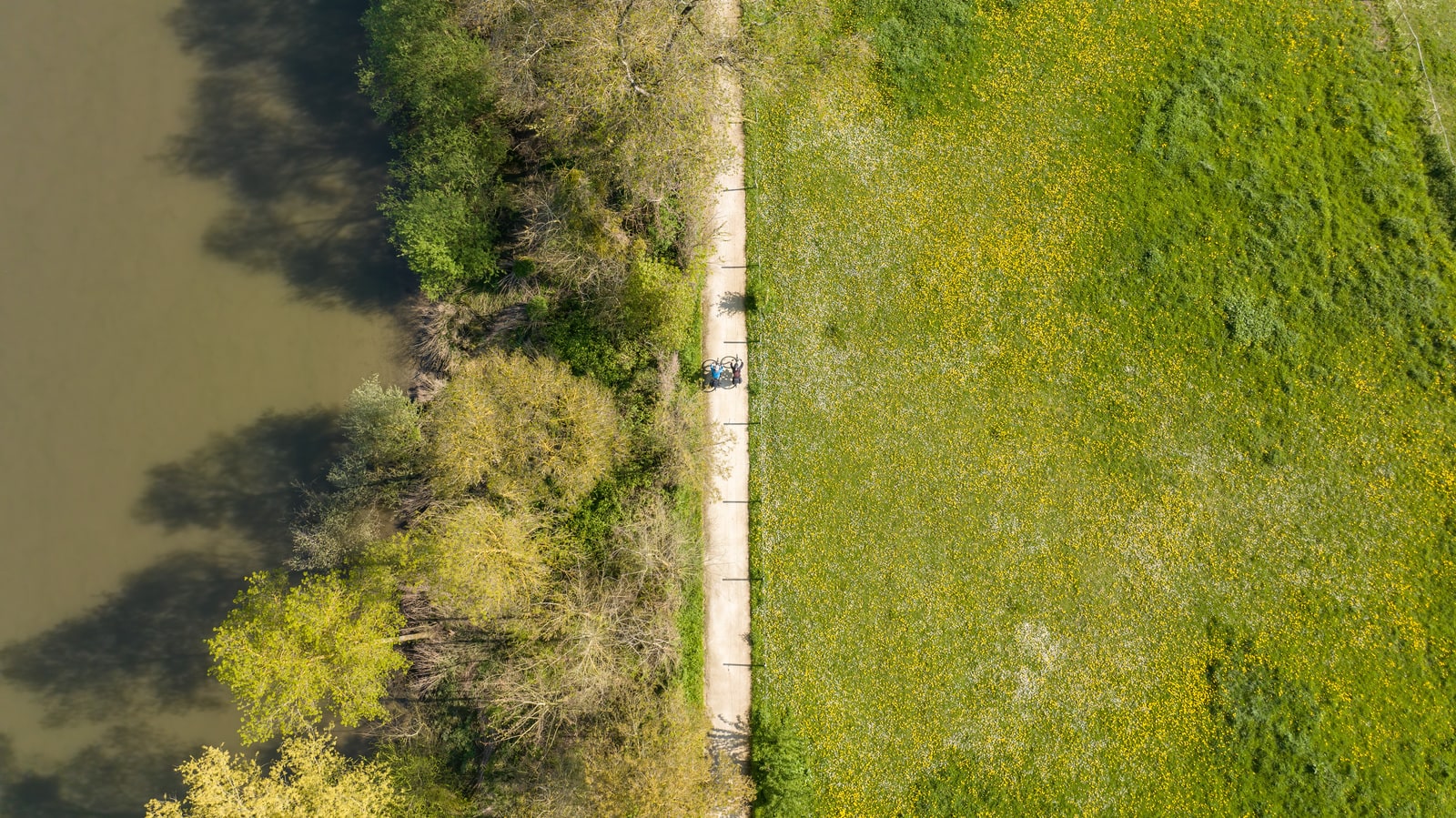 cyclistes sur voie verte le long d'une rivière en drone