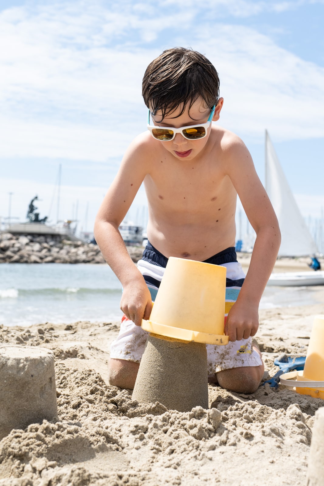 enfant fait un château de sable