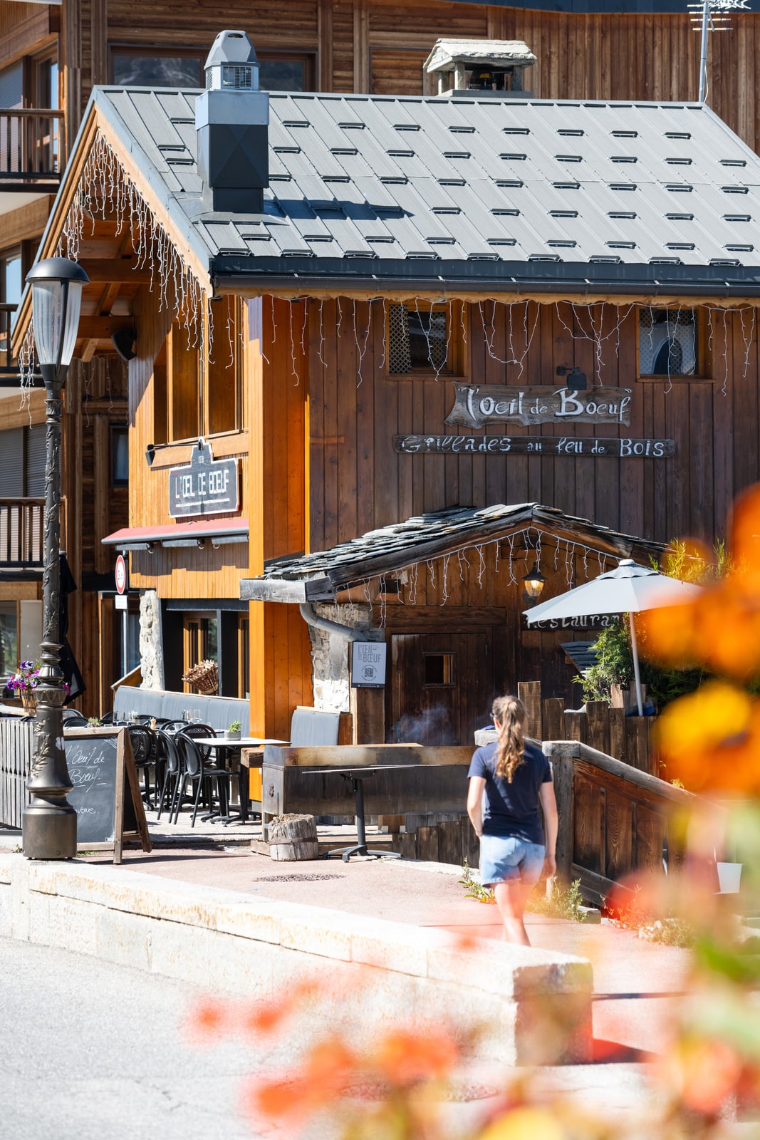 femme marche vers restaurant station de ski en été