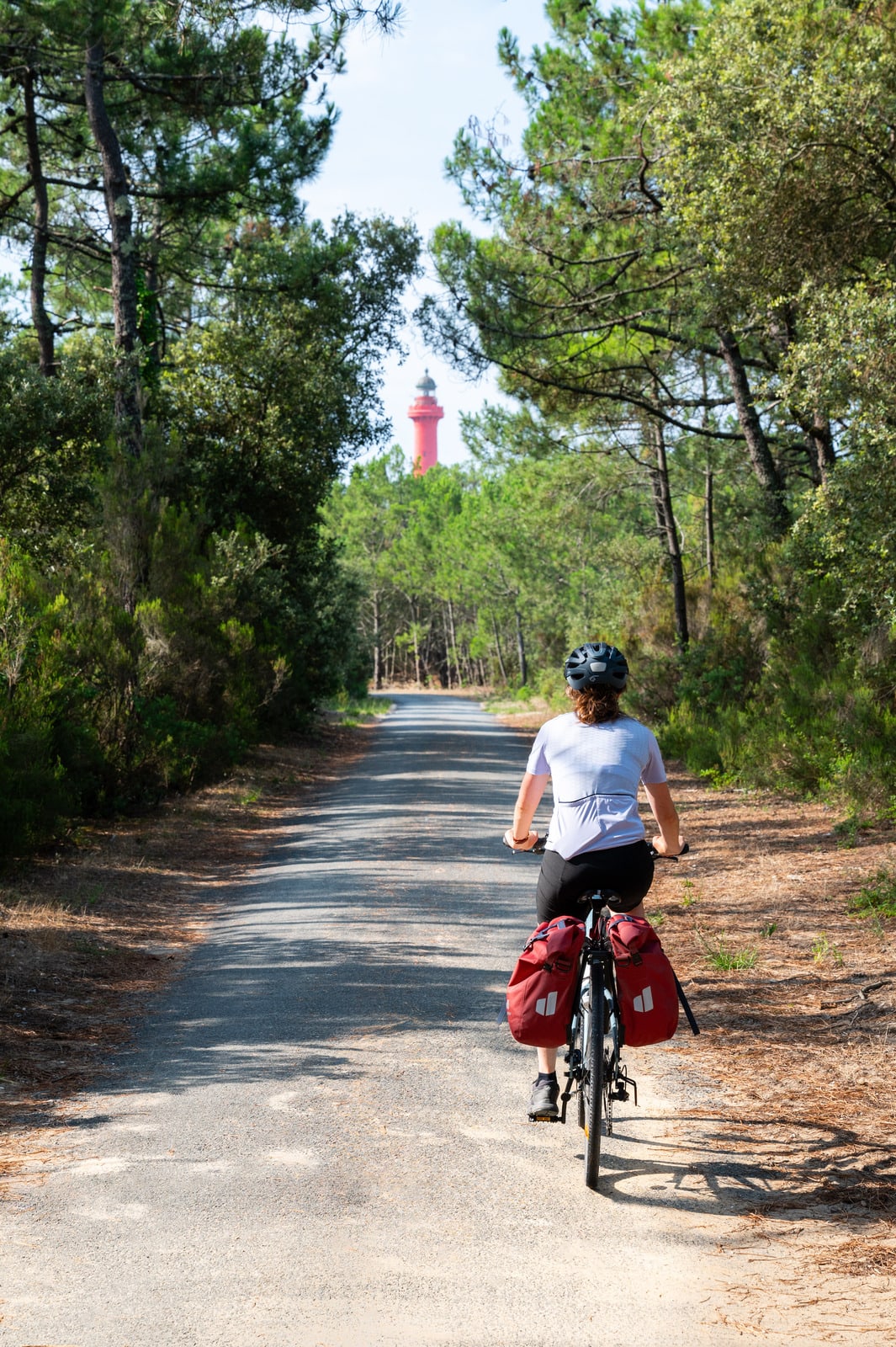 cycliste sur voie verte avec phare au fond